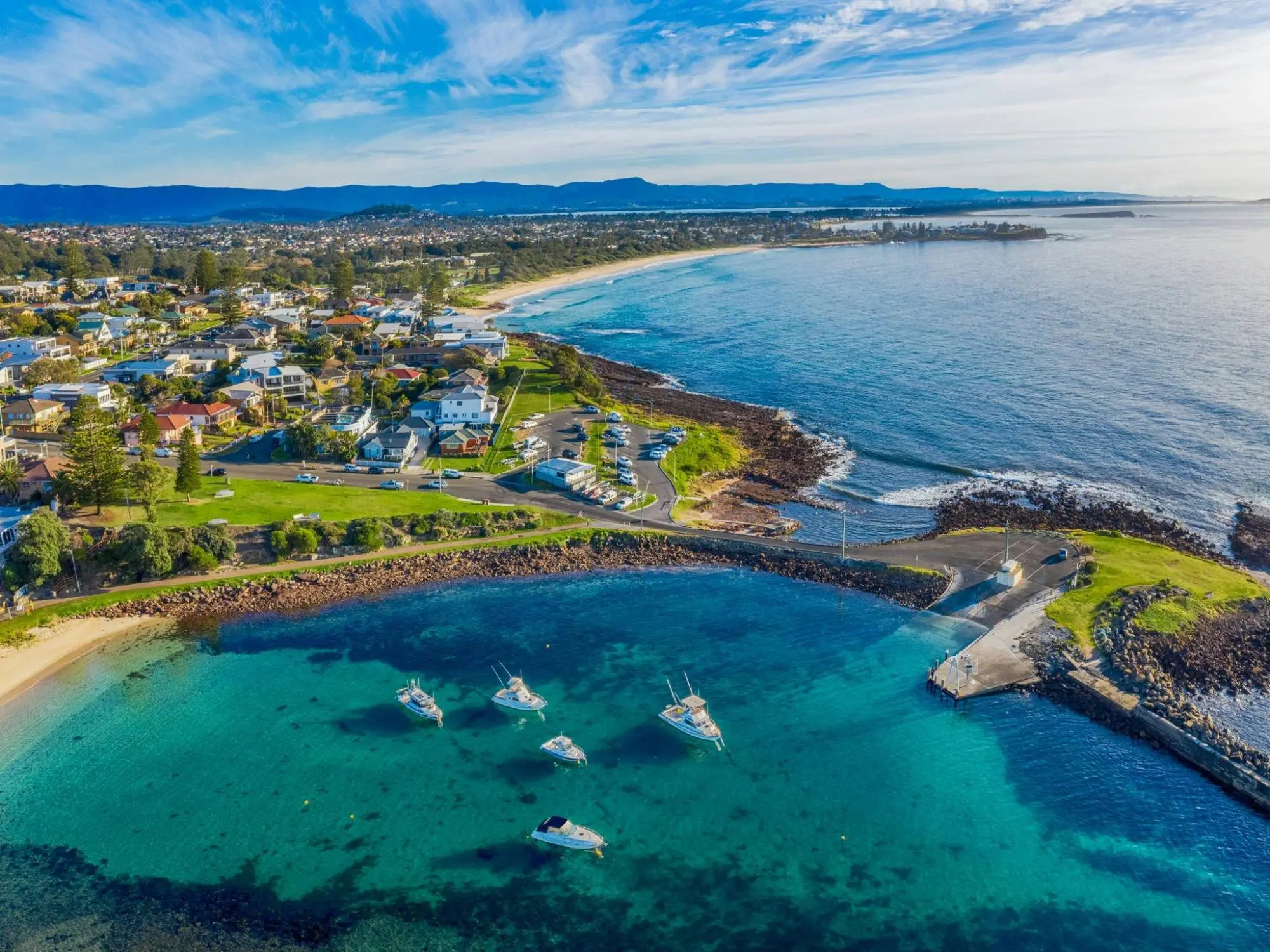 Aerial view of Shellharbour boat harbour and Shellharbour Village, looking north along the coast to the Illawarra escarpment
