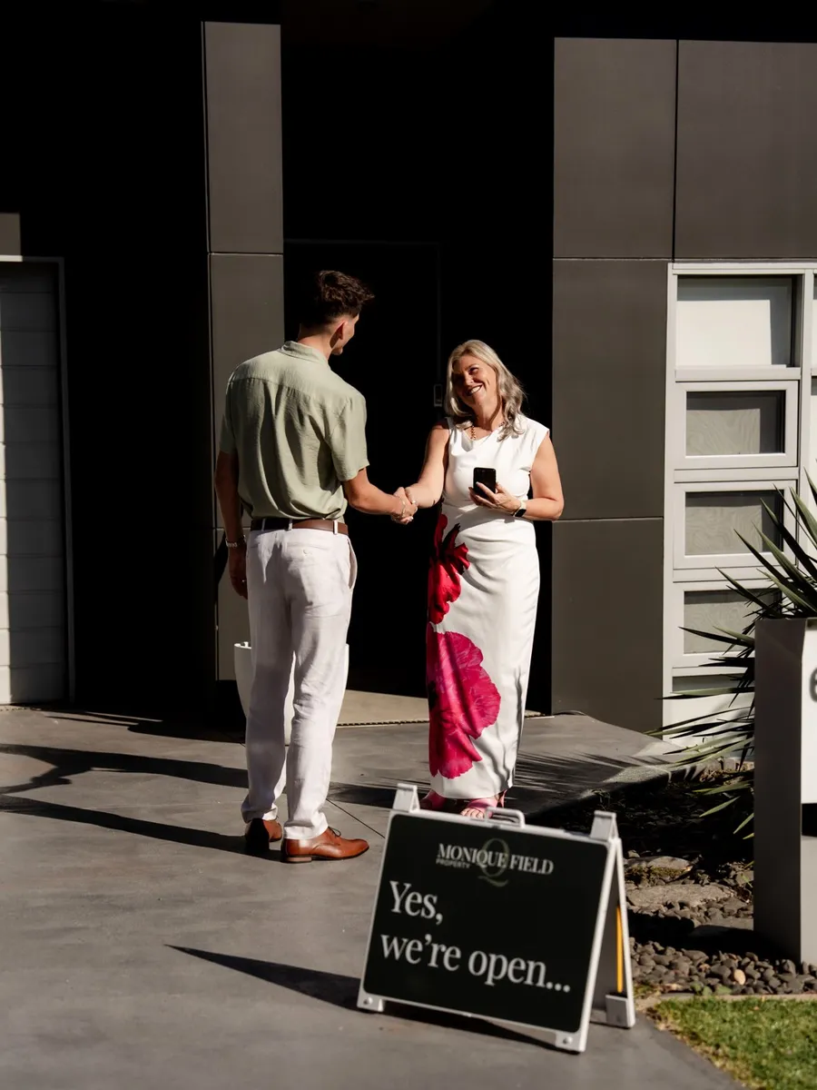 Phoenix Smith shaking hands with Monique Field outside an open home